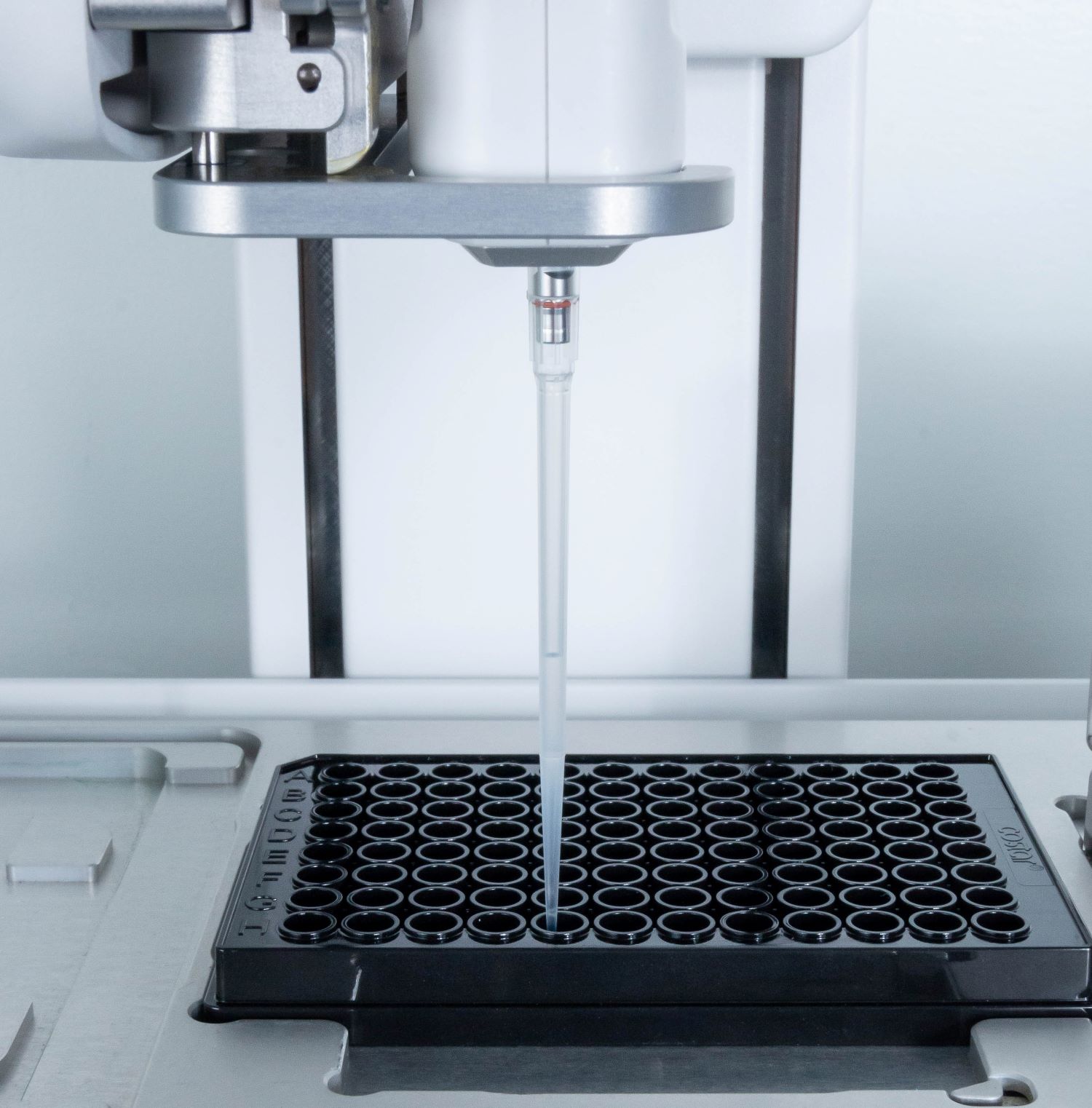 A close view of the D-ONE single channel pipetting module adding the positive product controls to the assay plate.