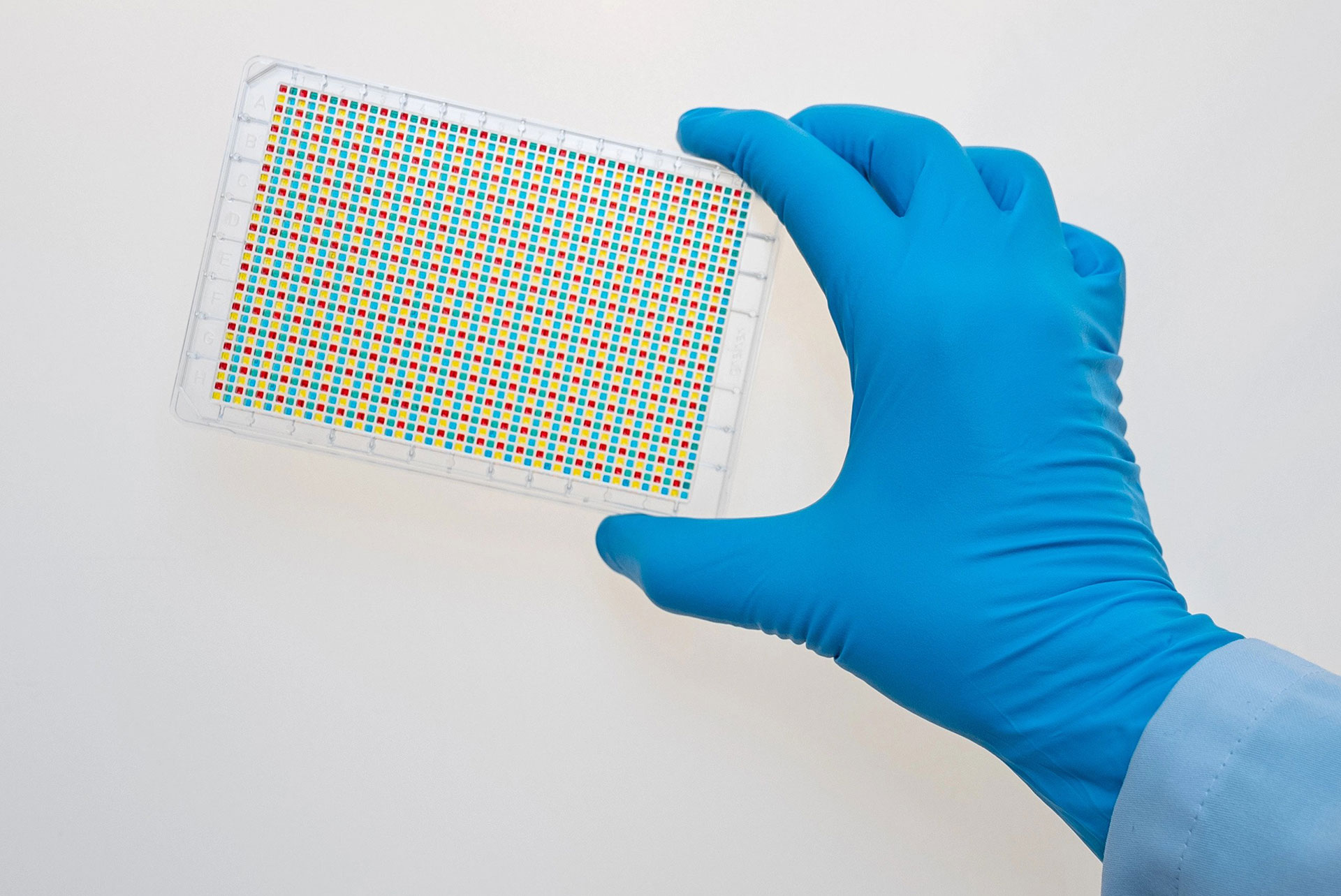 A hand showing the result of sample transfer from four 384 well plate to a 1536 well plate with the VIAFLO 384.