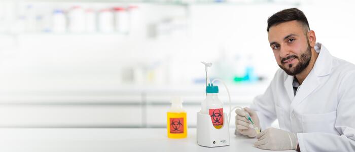 Scientist using a VACUSIP aspiration system with a biohazard symbol on it