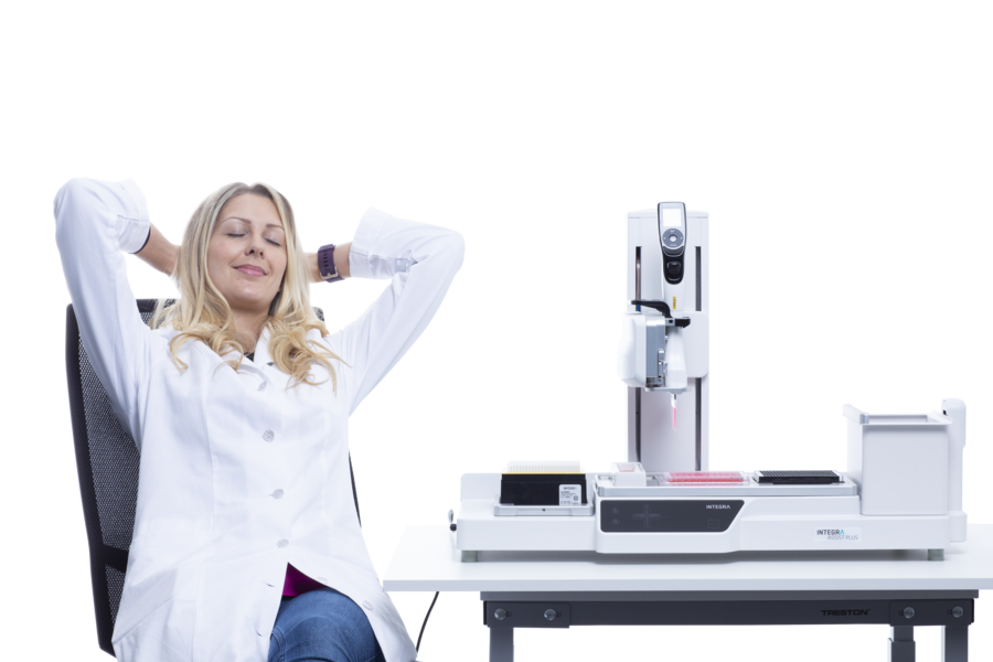 Picture of scientist sitting next to ASSIST PLUS 