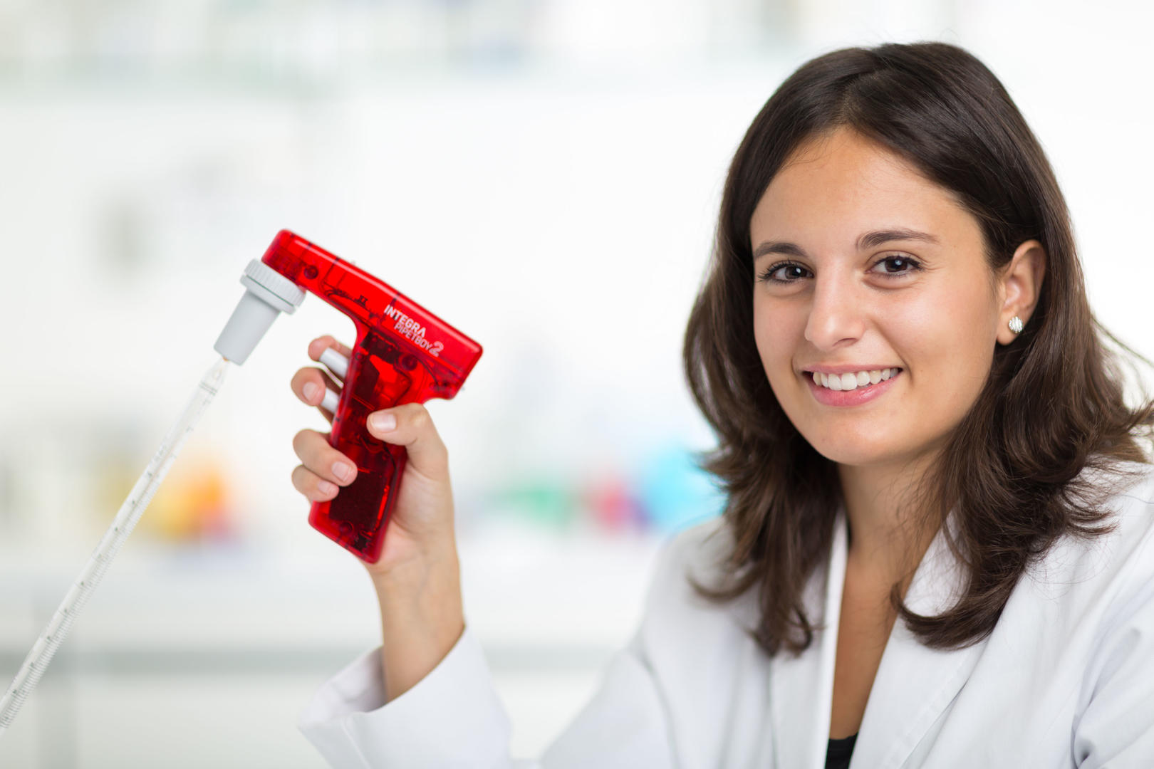 Scientist holding a red PIPETBOY acu 2 pipette controller