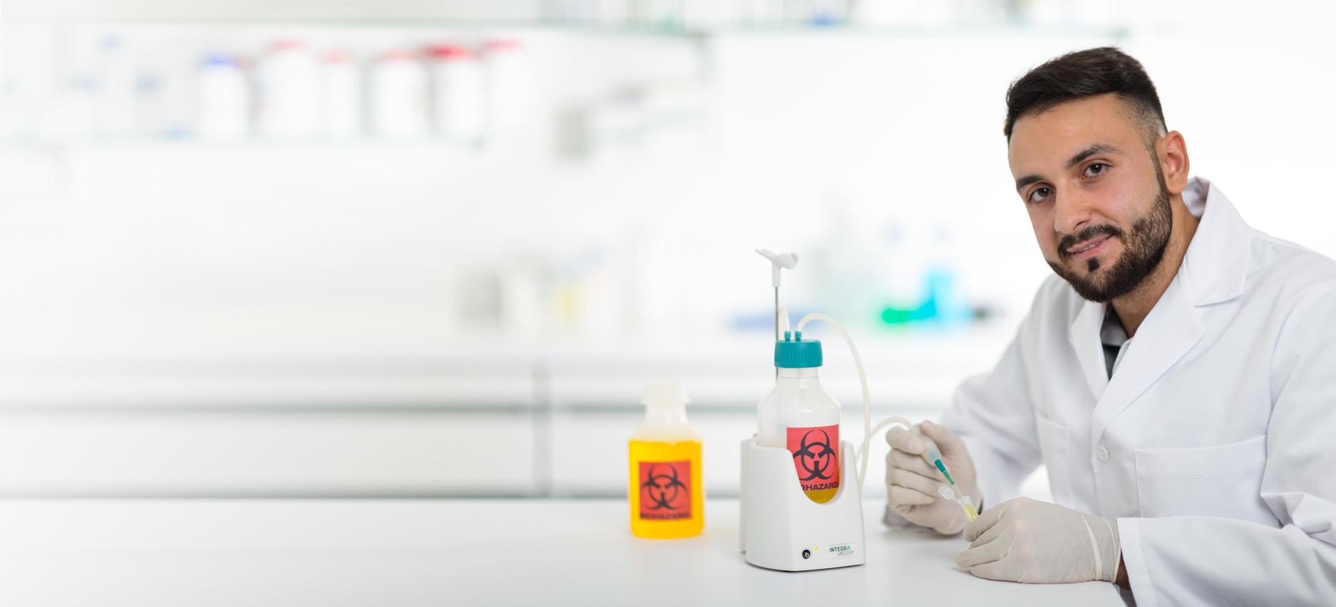 Scientist using a VACUSIP aspiration system with a biohazard symbol on it