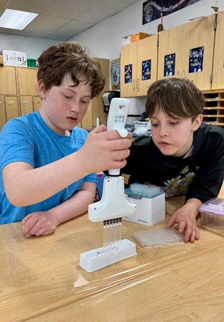 Two students using an INTEGRA Biosciences pipette