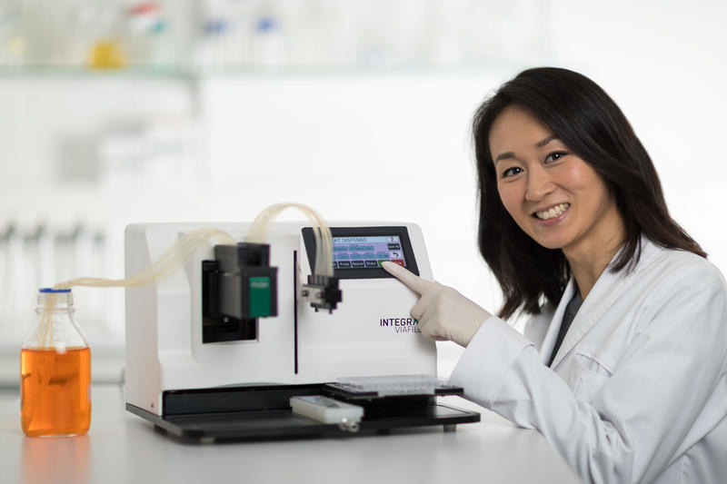 Scientist pointing at the color touch screen user interface of the VIAFILL rapid reagent dispenser.