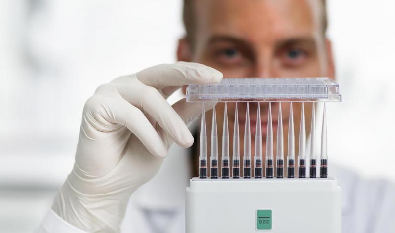 Scientifique avec une pipette multicanaux avec des pointes parfaitement alignées