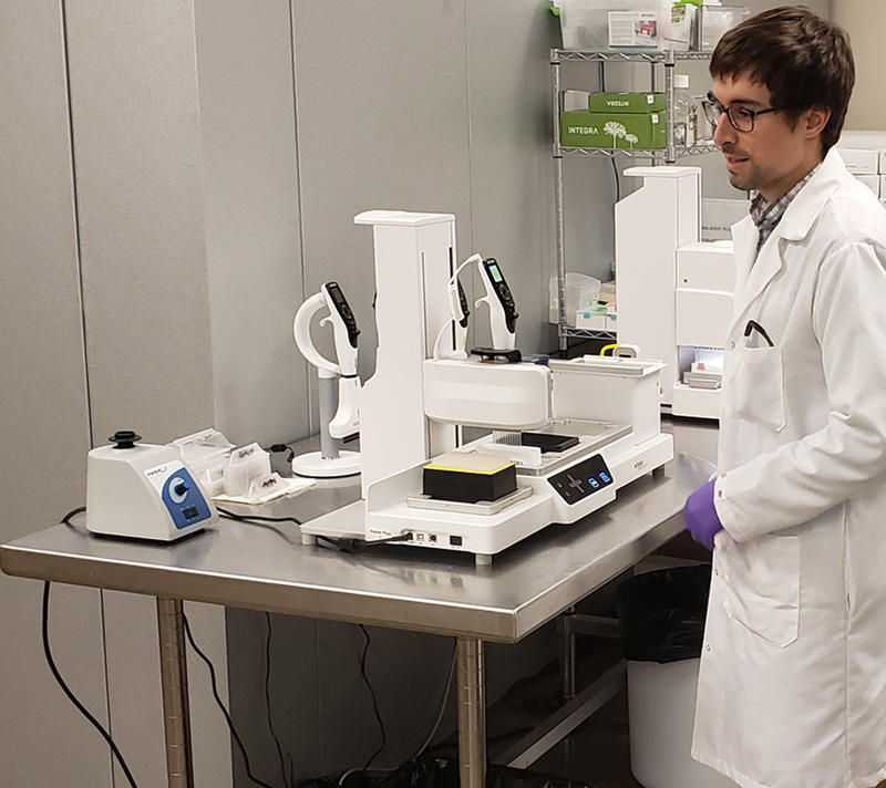 Scientist of Radix BioSolutions working with the ASSIST PLUS pipetting robot