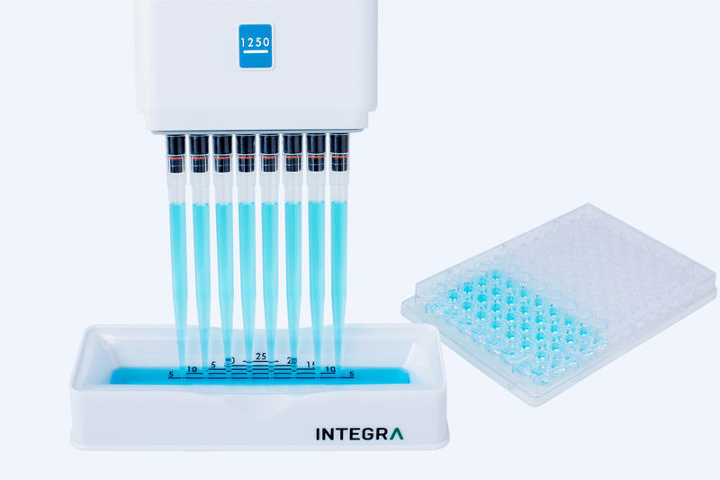 8 channel EVOLVE manual pipette transferring reagent from multichannel reagent reservoir to 96 well plate