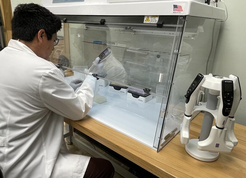 Scientist using a VOYAGER adjustable tip spacing pipette in the PCR laboratory at Axis Healthcare.