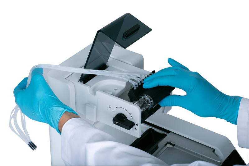 Scientist inserting an EasySnap dispensing cassette into the WELLJET reagent dispenser