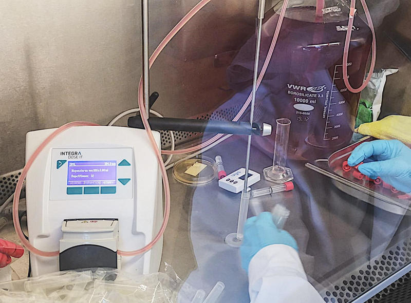 Scientist using the DOSE IT peristaltic pump in a laminar flow cabinet