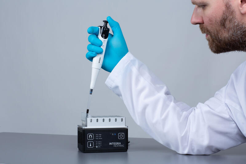 A male scientist manually mixing magnetic beads in a HEATMAG 1.5ml tube adapter. 