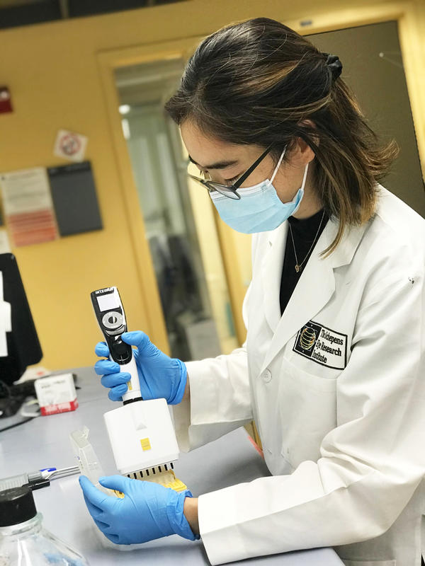 Scientist using a VIAFLO electronic multichannel pipette