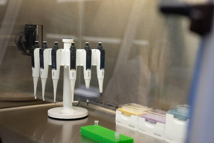 Sechs SWITCH-Hybridpipetten an einer Flex-Ladestation in einer Laminar-Flow-Kabine.